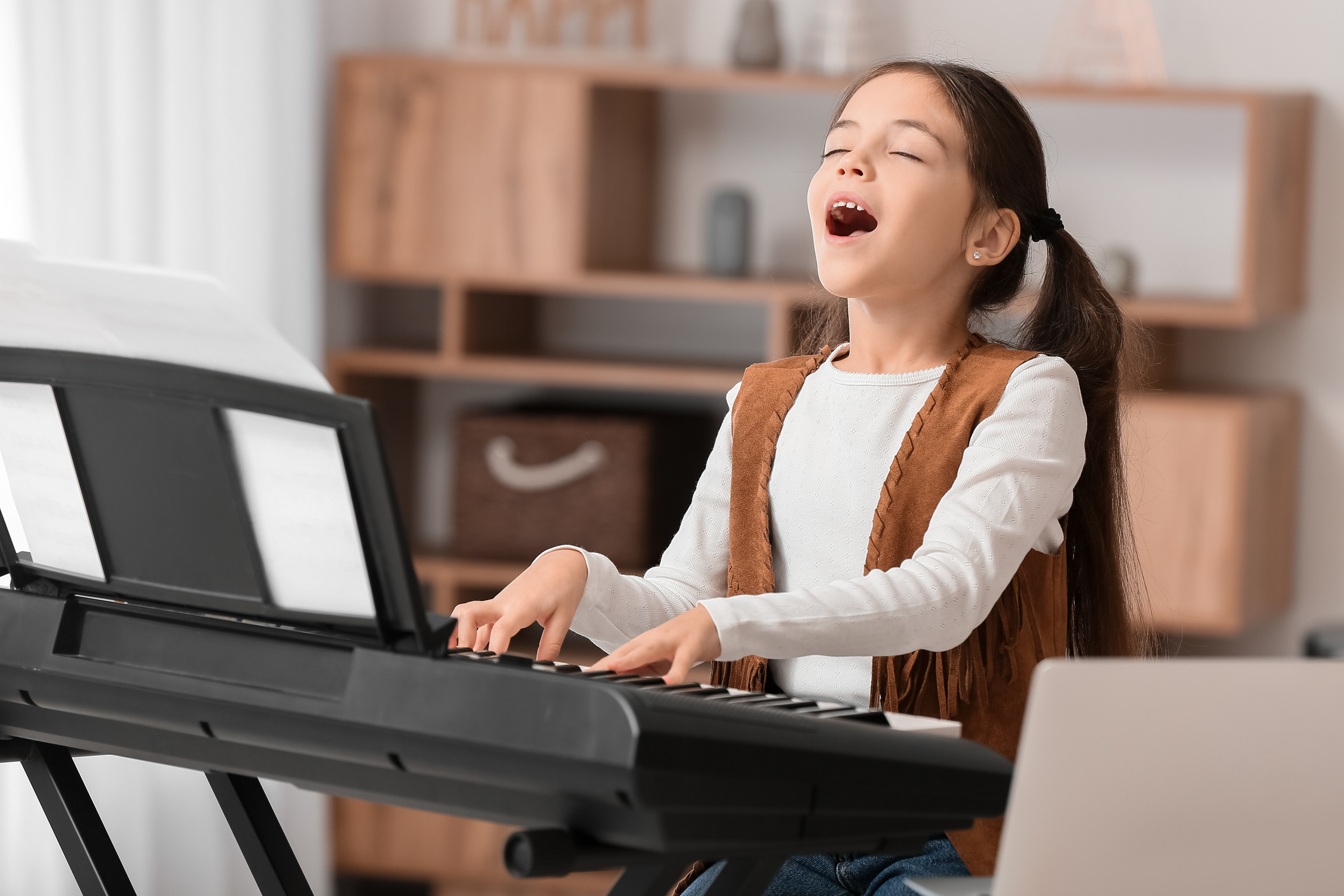 Little Girl Taking Music Lessons Online at Home